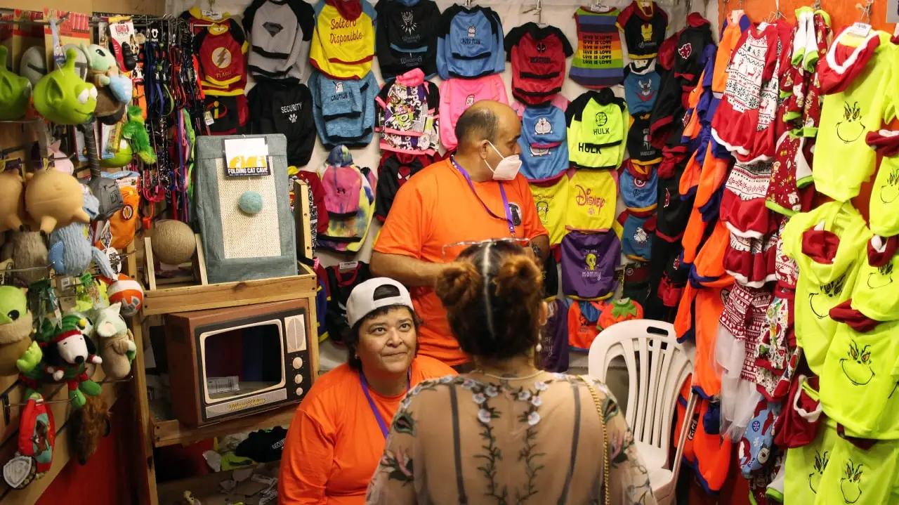 Personas posando en un puesto de venta de mangas y camisetas.