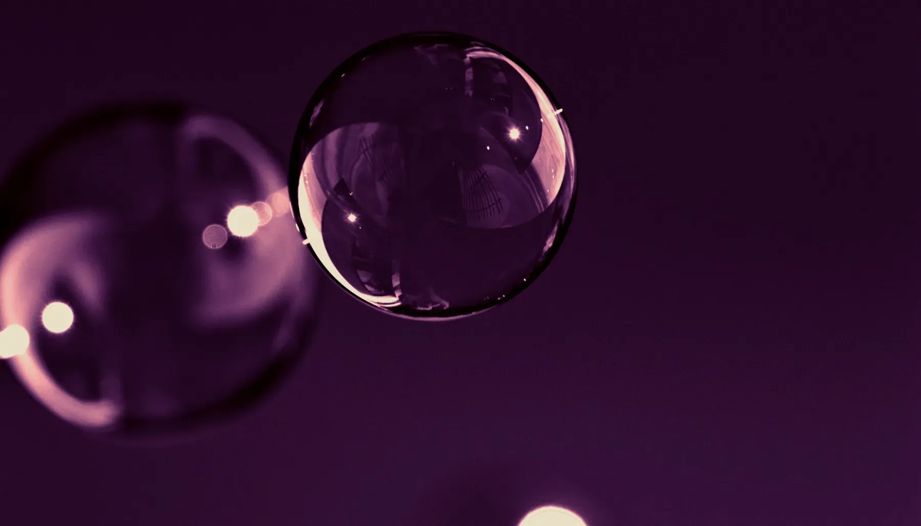 Burbujas flotando en un fondo violeta.