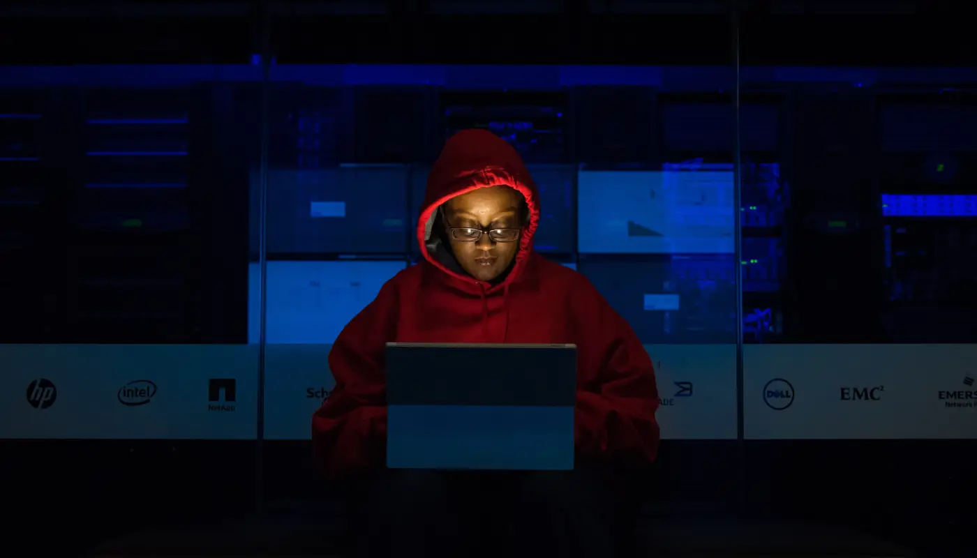 Persona usando una laptop en una habitación oscura.