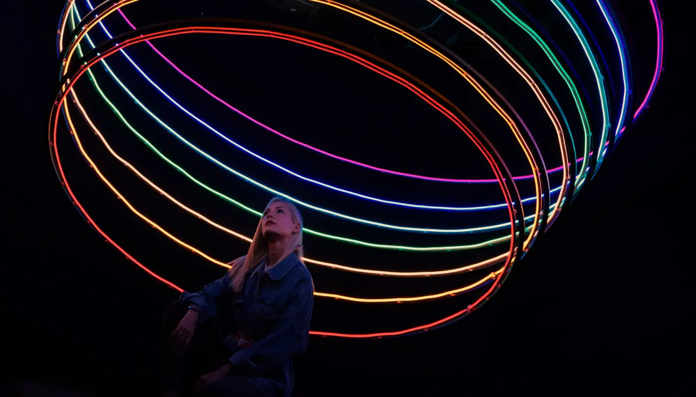 Mujer joven con aros LED de fondo.