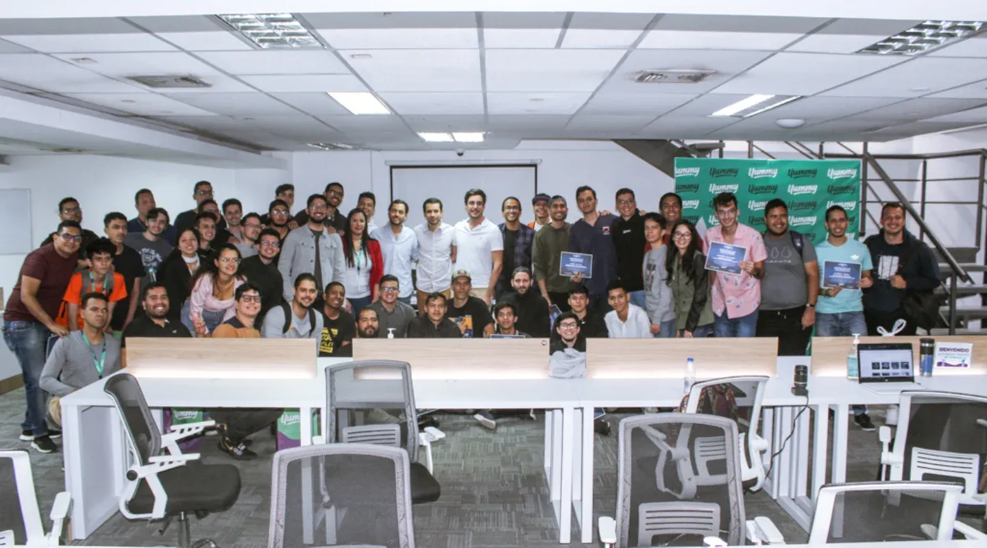 Foto grupal con participantes y organizadores de un evento en una sala de conferencias.